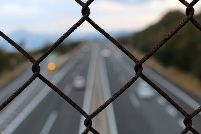 Close-up of chainlink fence against sky