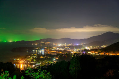 High angle view of illuminated buildings against sky at night