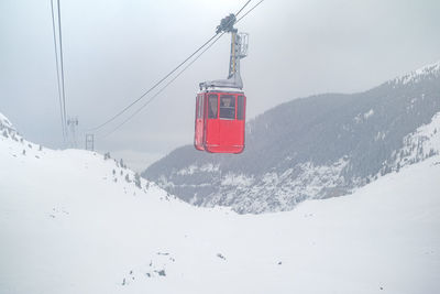 Red cable car on snow storm in fagaras mountains, balea lake, sibiu county, transylvania, romania