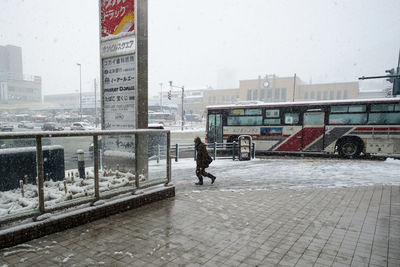 Man walking on street in city during winter