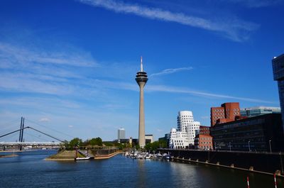 View of bridge over river and buildings against sky