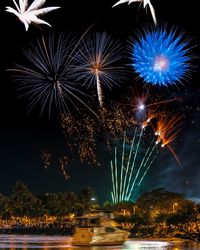 Low angle view of firework display at night