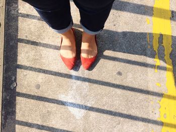 Low section of woman standing on footbridge