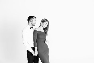 Elegant couple standing against white background