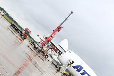 Low angle view of crane at construction site against sky