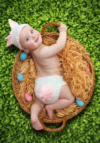 High angle view of cute baby girl lying in basket