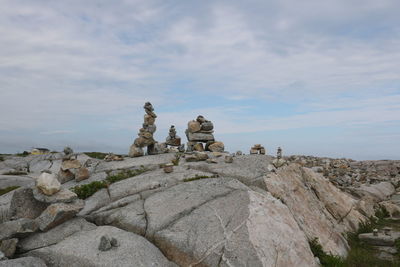 Statue of rock formations against cloudy sky