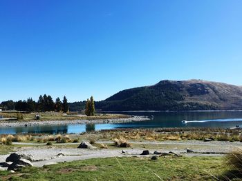 Scenic view of lake against clear blue sky