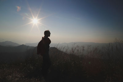 Man standing on mountain against sky during sunset