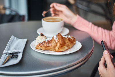 Midsection of woman eating food at cafe