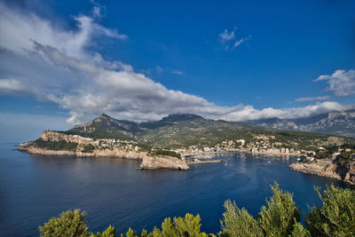 Scenic view of sea and mountains against blue sky