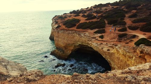 Rock formations by sea against sky