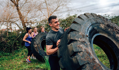 Friends turning wheels while exercising on land