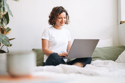 Portrait of young woman using laptop at home