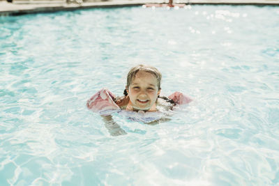 Young preschool age girl swimming in pool on vacation in palm springs