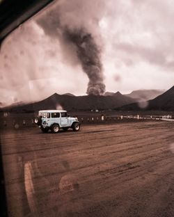 Car on road against cloudy sky