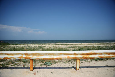 Empty bench overlooking calm sea