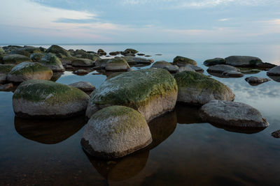 Close-up of rocks in sea against sky