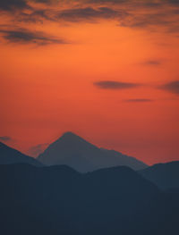 Scenic view of silhouette mountains against romantic sky at sunset