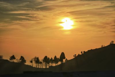 Scenic view of silhouette trees against romantic sky at sunset