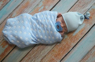 Close-up of baby boy sleeping on hardwood floor