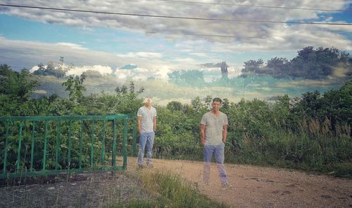 People standing by plants against sky