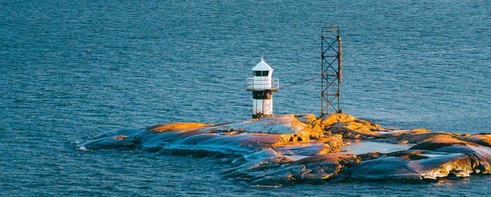 Lighthouse by sea against sky