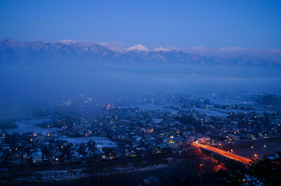 Aerial view of illuminated city against sky at night