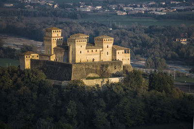 Aerial view of torrechiara castle and countryside hills at sunset, parma