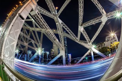 Light trails on bridge in city at night