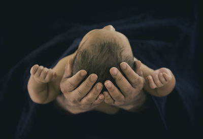 Close-up of man hand against black background