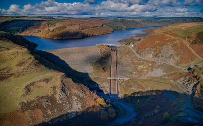 High angle view of river amidst mountains against sky