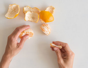 Cropped image of hand holding apple against white background