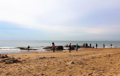 People on beach against sky