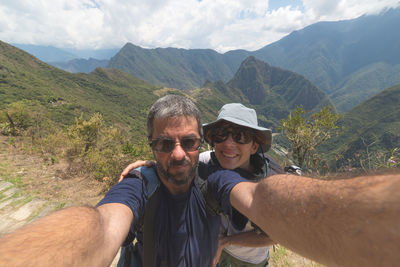 Man and woman taking selfie against mountain
