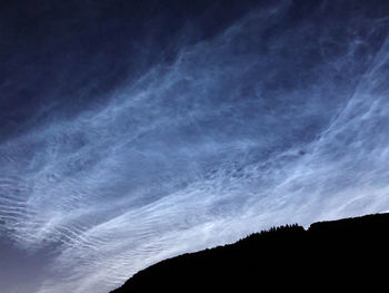 Low angle view of silhouette mountain against sky at night