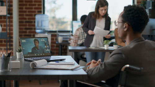 Side view of woman using laptop at office