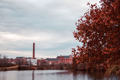 Scenic view of river by buildings against sky