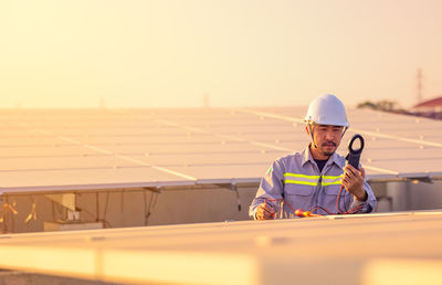 Engineer inspects solar panels on roof of modern house. alternative energy ecological concept.