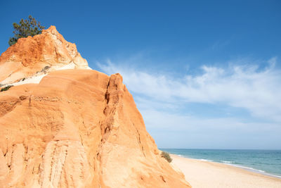 Rock formation on beach against sky