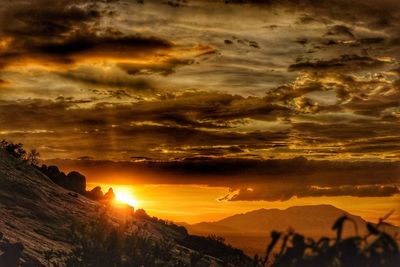 Scenic view of dramatic sky over silhouette landscape