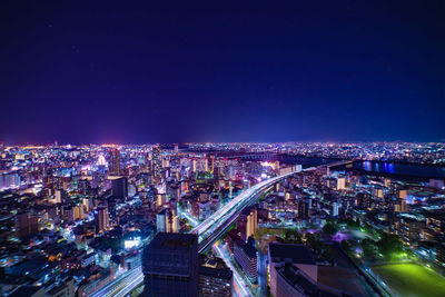 High angle view of illuminated cityscape against sky at night