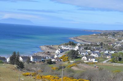 High angle view of townscape by sea against sky