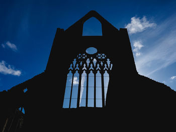 Low angle view of silhouette building against sky