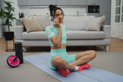 Young woman sitting on sofa at home