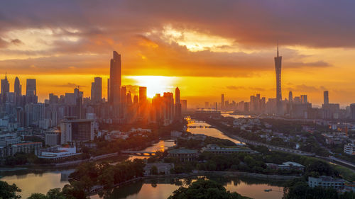 Aerial view of buildings in city during sunset