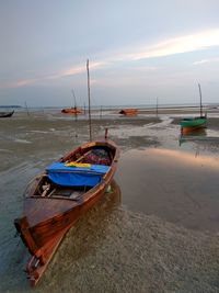 Boats moored on beach against sky