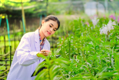 Female scientist examining crops growing at farm
