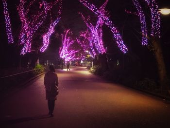 Rear view of man on road at night