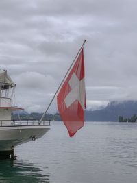 Red flag on sea against sky